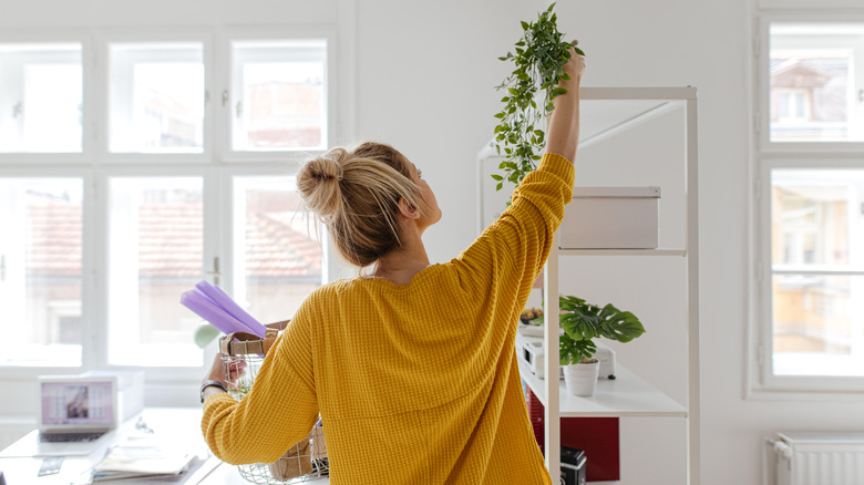 Woman hanging plant