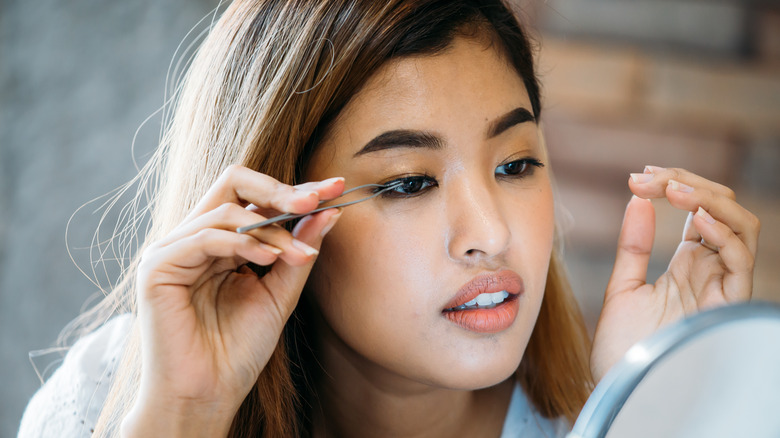 Applying false eyelashes