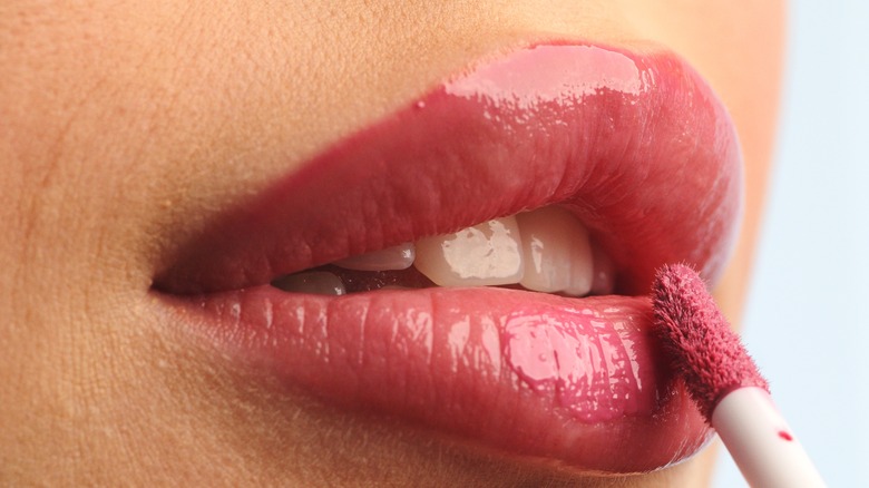 closeup of woman applying lipstick with lip brush