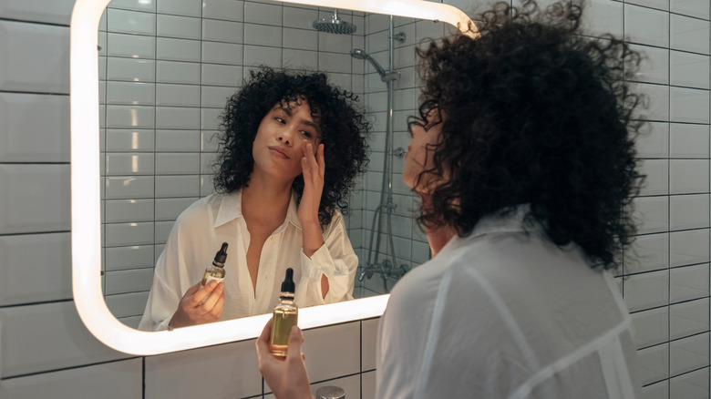 Young woman applying hyaluronic acid serum 