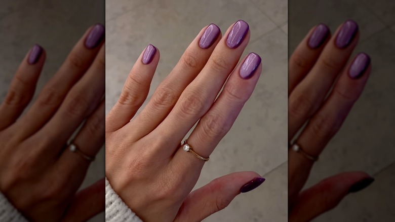 A screen grab of a woman with purple chrome nails