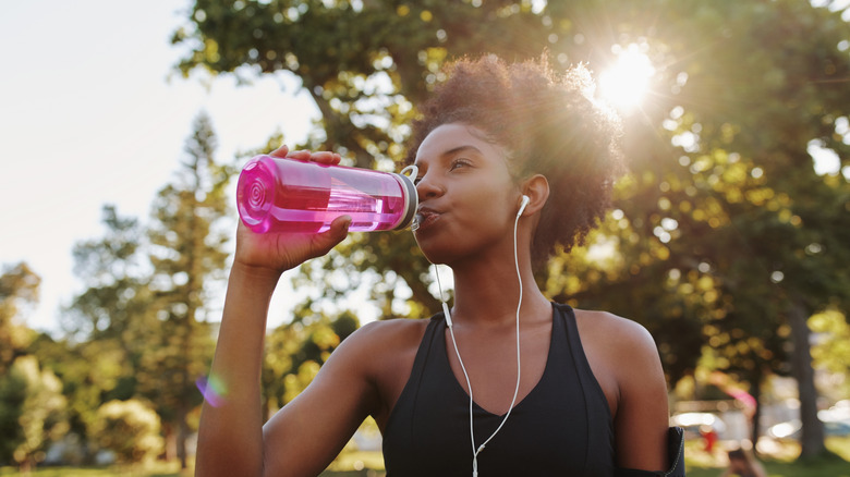 A woman on a rub takes a sip of water