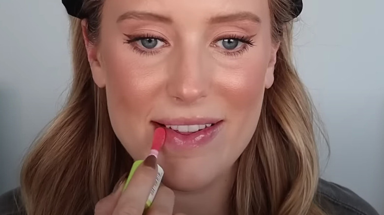 woman applying lip oil 