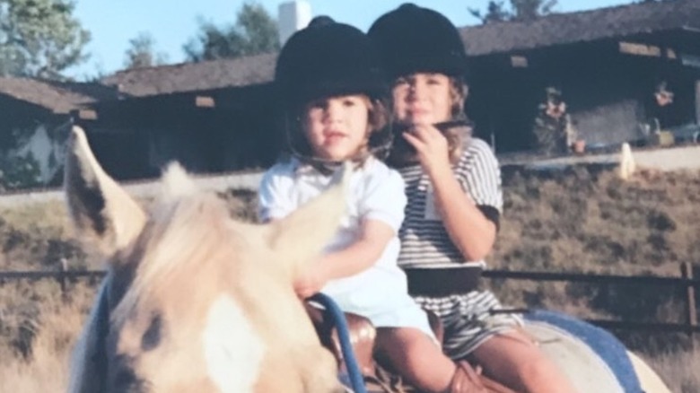 A young Kate Mansi and her sister riding a horse.