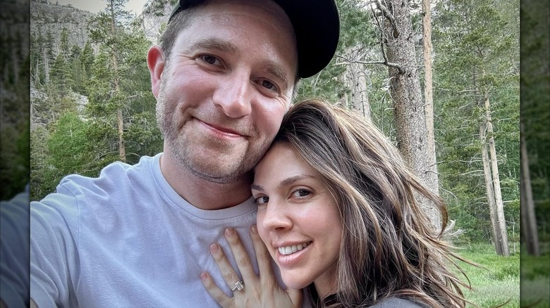Kate Mansi smiling and showing her engagement ring while hugging Matt McInnis.