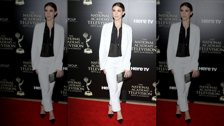 Kate Mansi posing in a black and white outfit on the red carpet at the 2014 Daytime Emmys