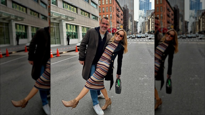 Giada DeLaurentiis in a striped dress and ankle boots while posing with a man in New York