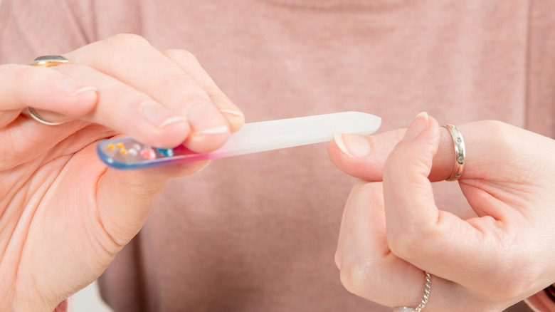 woman using glass nail file 