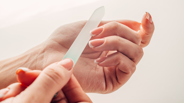 woman using glass nail file 