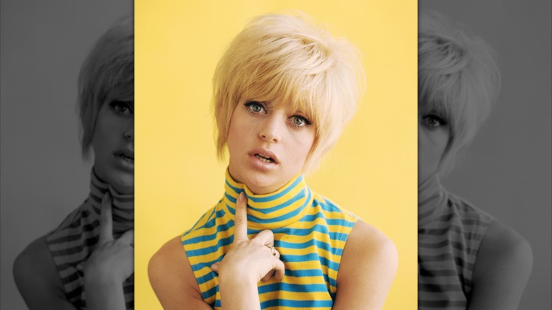 A portrait of Goldie Hawn wearing a striped yellow and blue top in 1965.