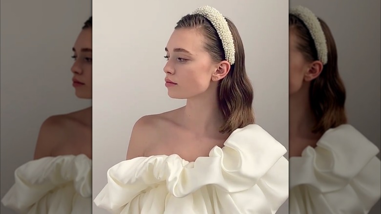 A woman wearing a wedding dress with a bridal headband