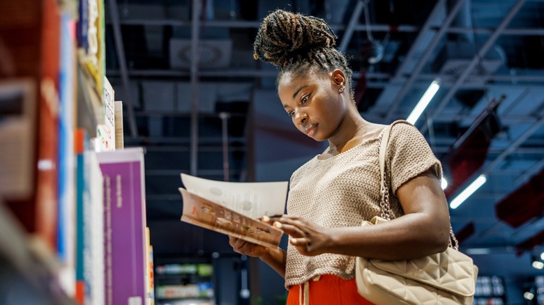 A woman reading a book in a book store