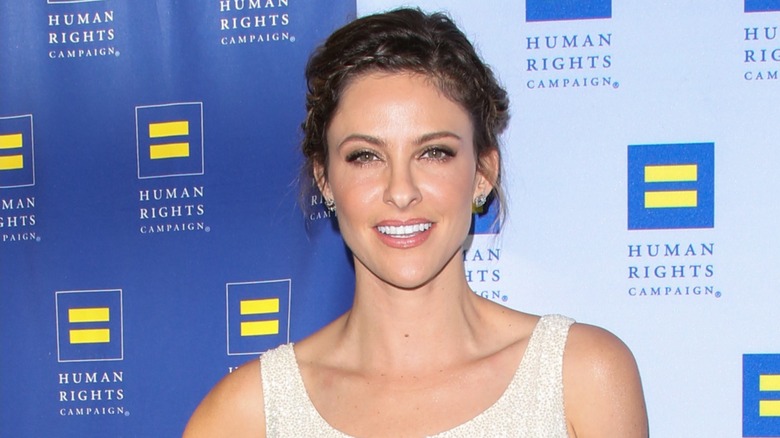 Jill Wagner posing on the red carpet in front of a blue background in 2015
