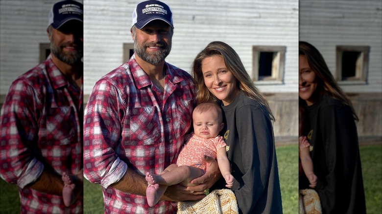 David Lemanowicz and Jill Wagner posing outside with their baby daughter