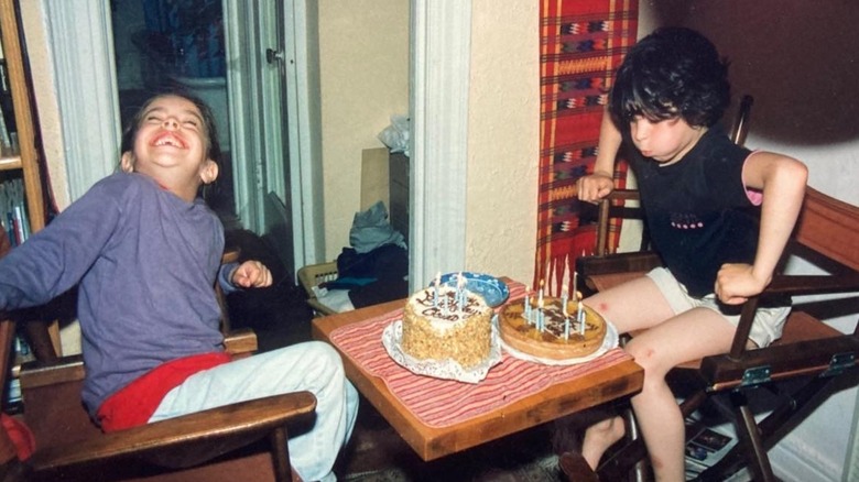 Young Oona Chaplin and her cousin posing with birthday cakes