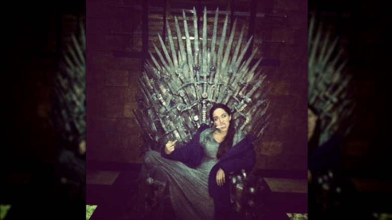 Oona Chaplin sitting in the "Game of Thrones" throne in 2012