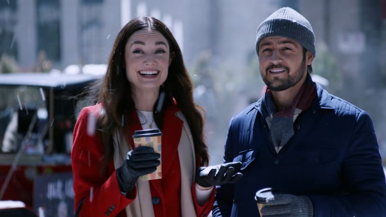 Tyler Hynes in a coat and hat with a woman in a red coat on "On the 12th Date of Christmas."
