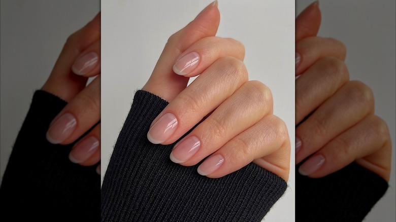 A close-up of a hand with a sheer French manicure