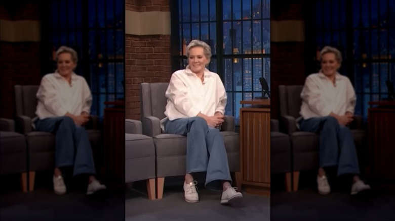 Jean Smart sits wearing a white shirt and jeans