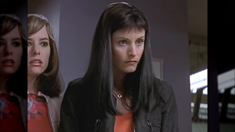 Courtney Cox as Gale Weathers in "Scream 3" with chest-length dark hair and very short bangs