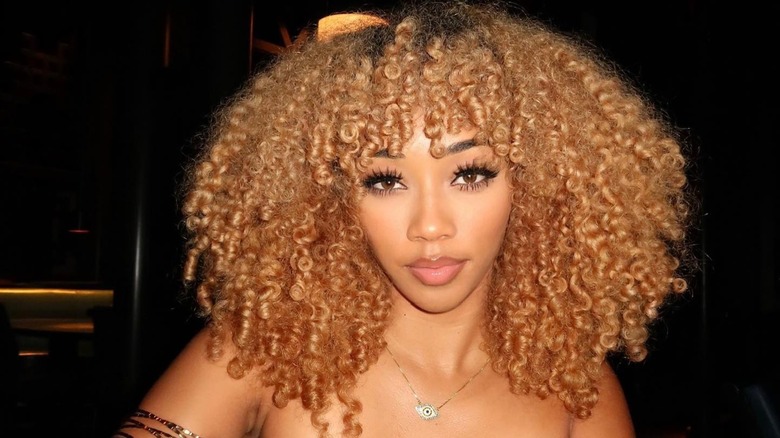 A woman with curly, strawberry blond hair