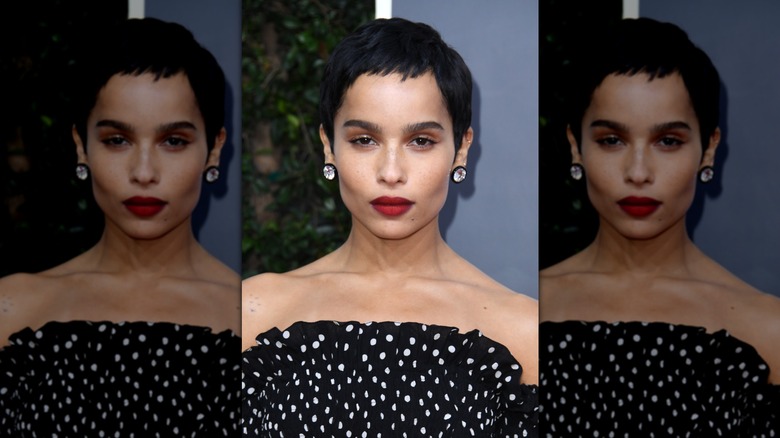 Zoë Kravitz wearign her jet-black hair in a pixie cut and red lipstick