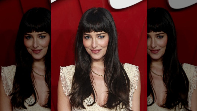 Dakota Johnson wearing a lace dress with long brown layers and bangs