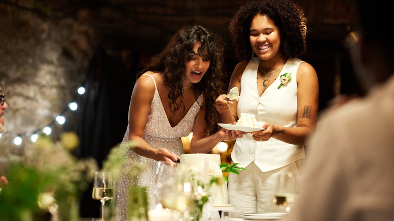 Young couple cutting wedding cake