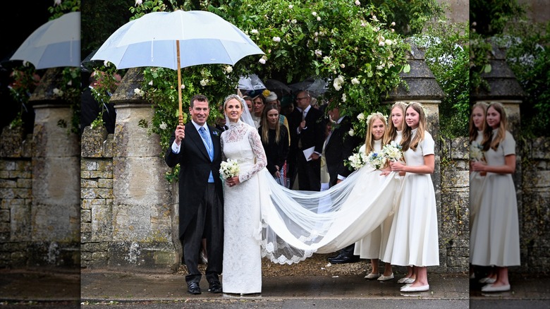 Wedding photo showing Peter Phillips holding an umbrella with Harriet Sperling, while the couple's three daughters hold the end of the train
