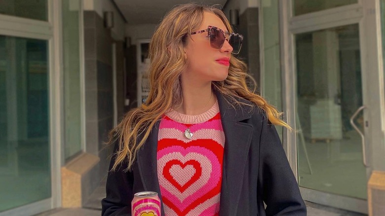 Woman posing in heart sweater and jacket