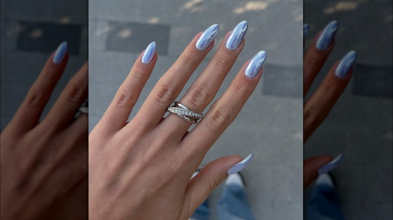 A hand with icy blue nails and silver rings