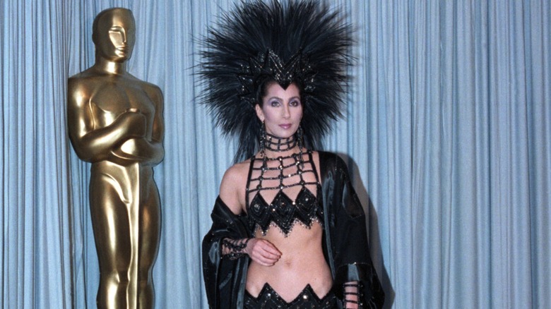 Cher wearing a huge headdress and exposing her midriff on the 1986 Oscars red carpet