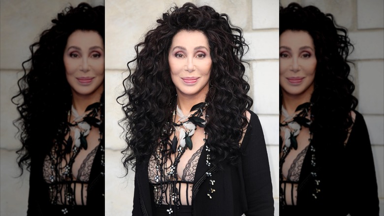 Cher smiling at the "Mamma Mia! Here We Go Again" premiere in an all-black outfit in 2018