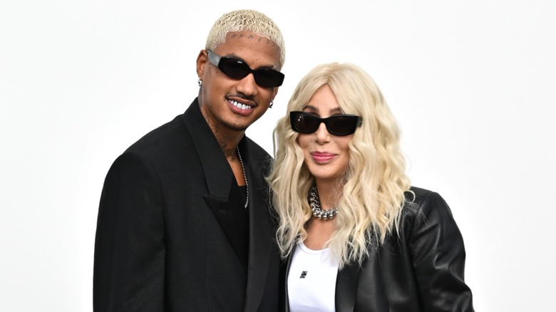 Cher and her boyfriend AE Edwards posing in front of a white background in 2022