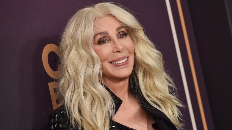 Cher smiling on the red carpet with long, blond hair