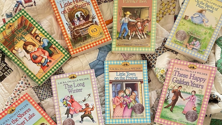 The Little House on the Prairie book series resting on a bed