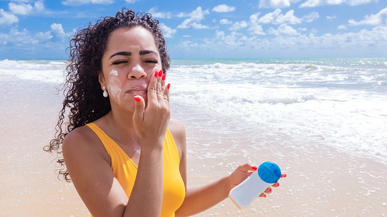 Woman applying sunscreen to her face