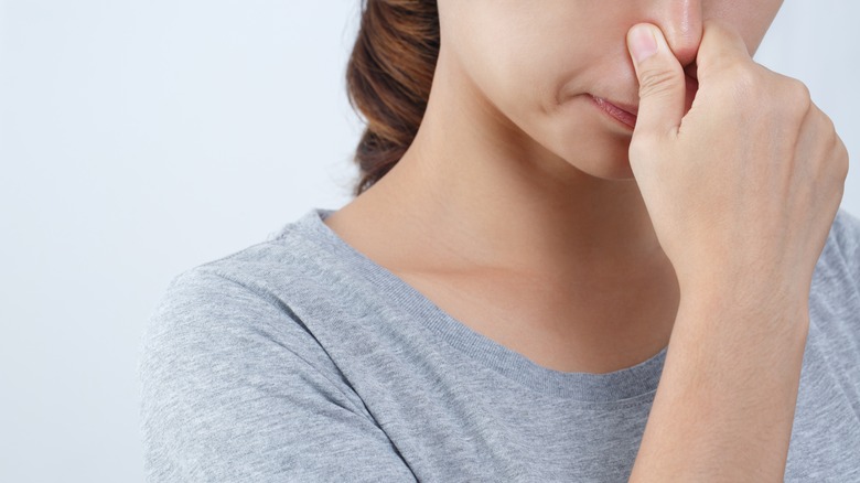 Woman plugging her nose