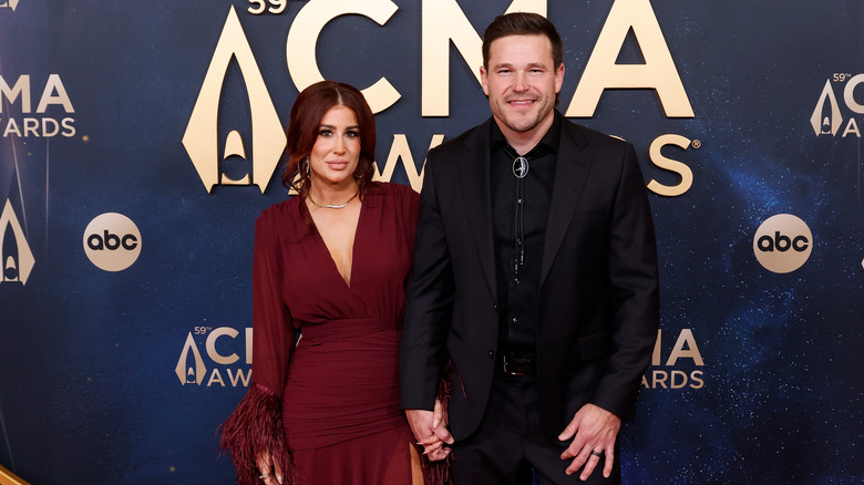 Chelsea DeBoer wearing red dress alongside husband Cole