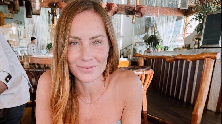 Mina Starsiak Hawk posing for a photo while sitting at a restaurant table