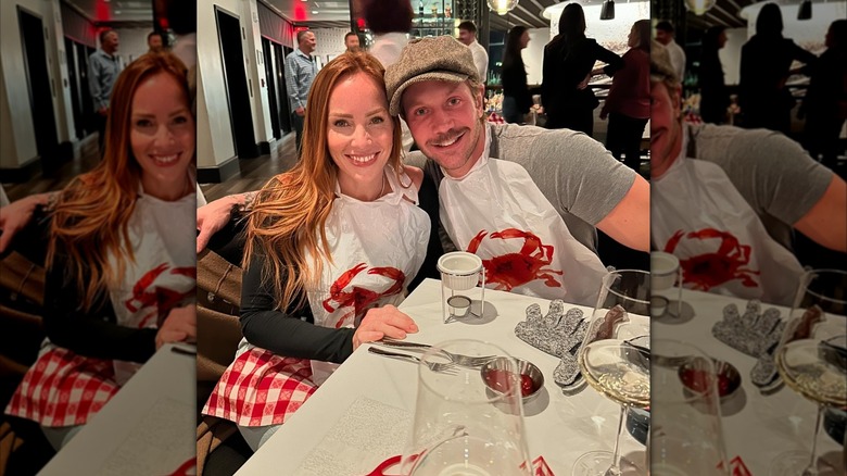 Mina Starsiak Hawk posing with her husband at a seafood restaurant