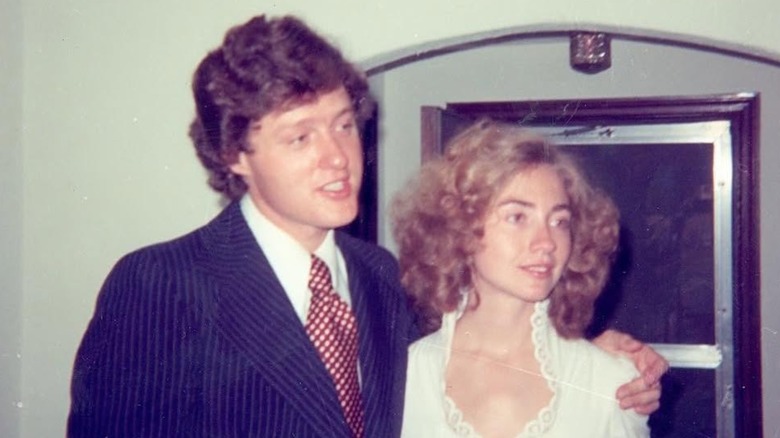 Bill Clinton in a suit and Hillary Clinton in a white dress on their wedding day in 1975
