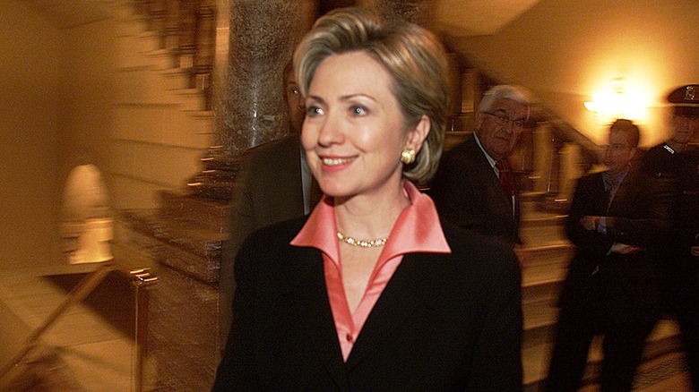 Hillary Clinton in a black blazer over a shiny pink top while inside the Capitol building in 2000