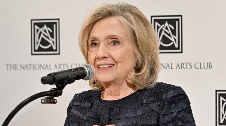 Hillary Clinton speaking into a microphone at the Medal of Honor in Fashion honoring Donna Karan event in 2026