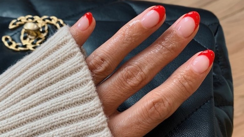 A woman win an orange-red French manicure