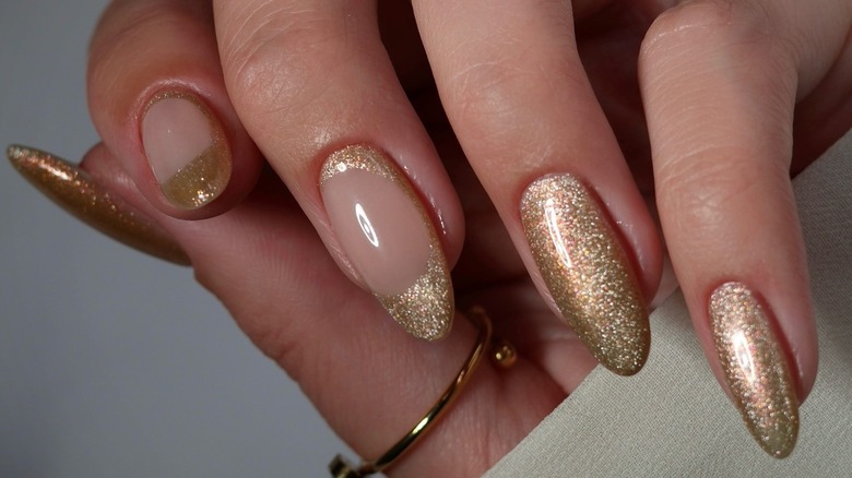 A woman with gold glitter nails