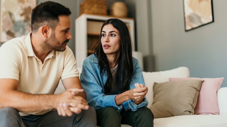 Woman and man on couch having serious conversation