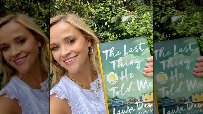 Reese Witherspoon taking a selfie while holding "The Last Thing He Told Me" by Laura Dave