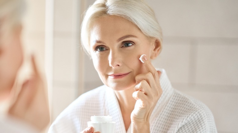 woman applying cream on skin