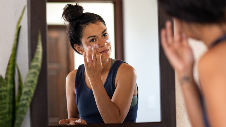 Woman doing skincare in mirror